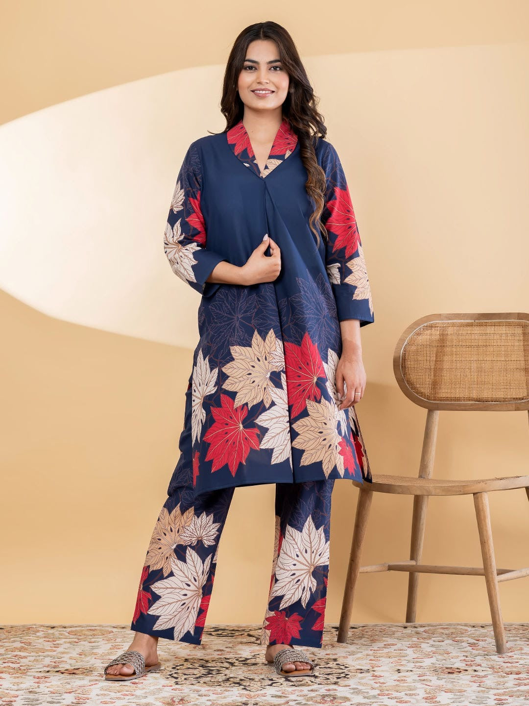 Woman wearing a navy blue floral outfit standing against a beige background